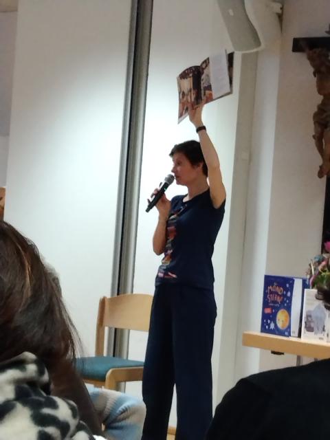 Lena Raubaum hält ein Buch hoch